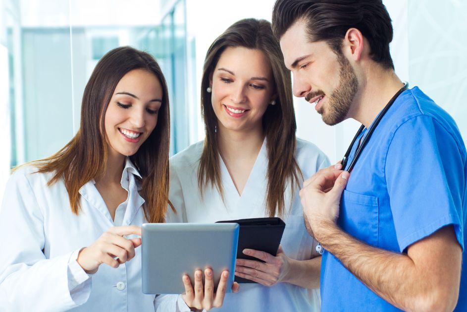 Three doctors looking at a tablet